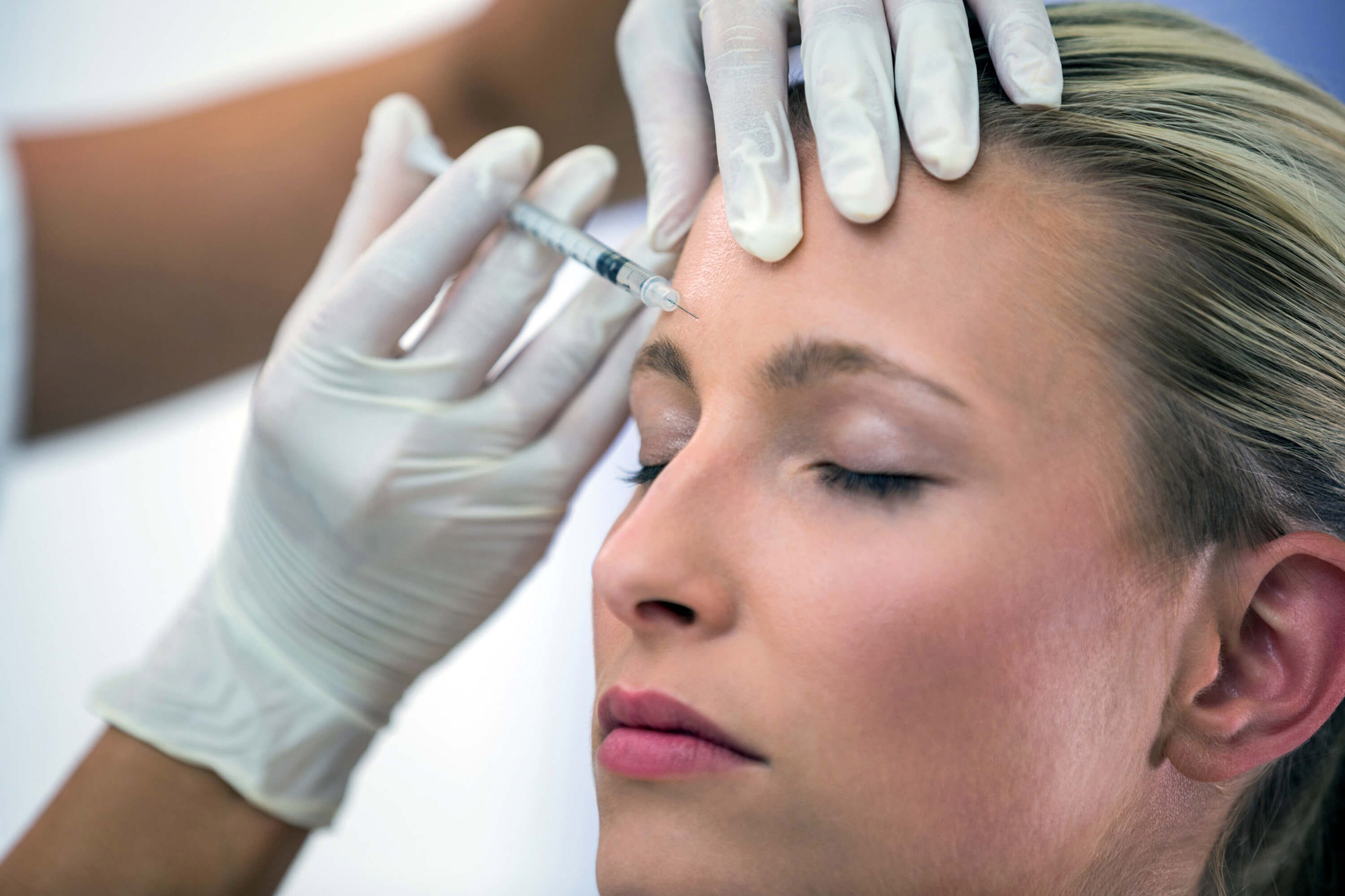 Mujer recibe una inyección de Botox en las cejas